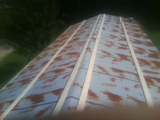 Rusted metal roof panels with new wood purlins before replacement — Storm Damage Roof Repair in Reston by Roofing Brothers