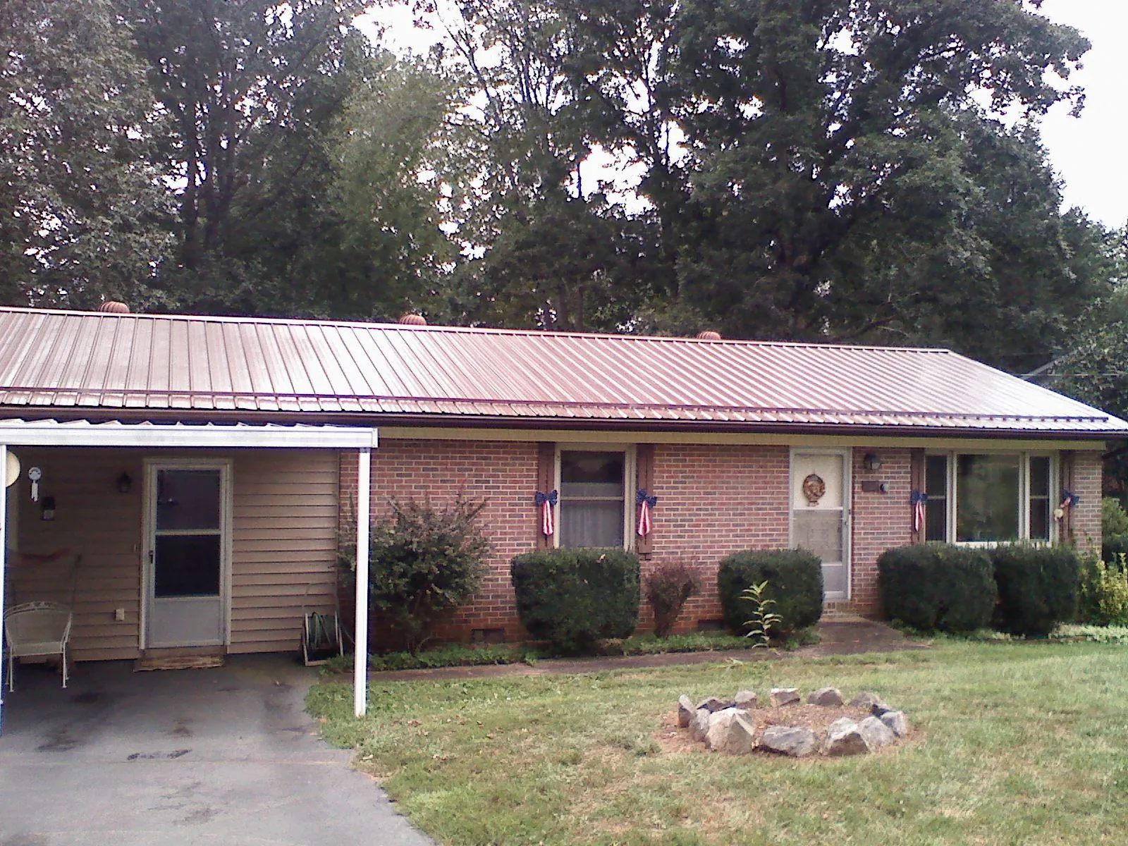 Bronze metal roof and carport on a brick ranch home — Roof Repair work by our crew in Reston